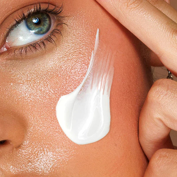 cream lotion on women's cheek 