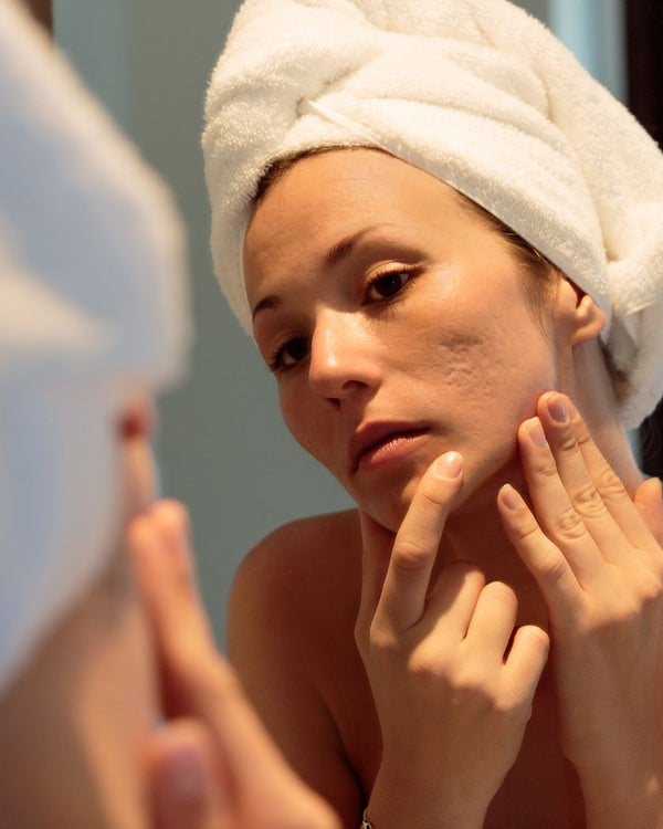 woman is looking at her skin