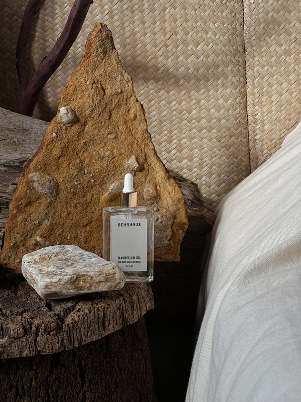 MAGNESIUM OIL ON THE NIGHTSTAND NEXT TO BED WITH STONES