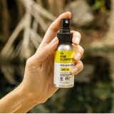 Person holding Raw Elements SPF 50 mineral sunscreen spray outdoors