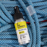 Raw Elements SPF 50 mineral sunscreen spray on blue towel at the beach