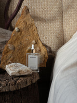 Behrhaus Magnesium Oil styled with natural stone, wood, and linen textures in a warm wellness-inspired setting.