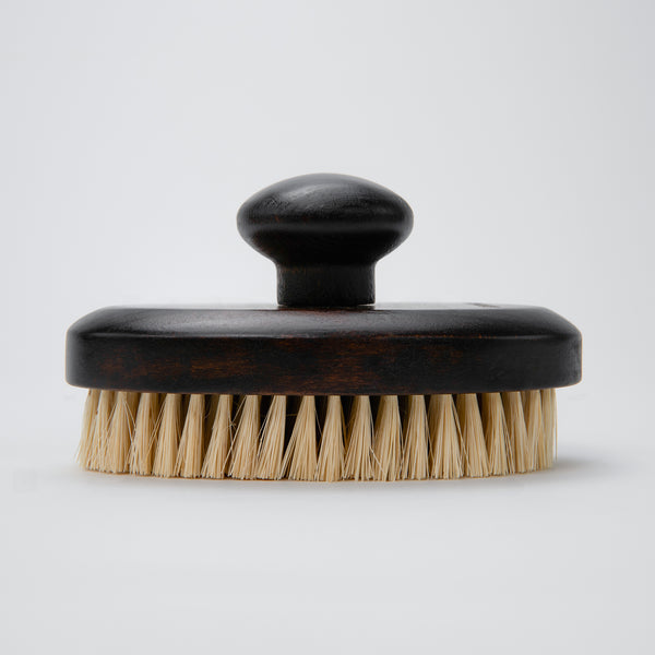 exfoliating dry brush made with dark wood and natural bristles