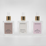 Three Behrhaus magnesium oil bottles with gold droppers in Vanilla, Original, and rose on a white background.