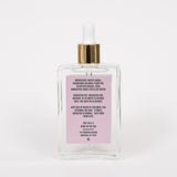 Back view of Behrhaus rose Magnesium Oil bottle showing ingredient list, usage instructions, and product details on a minimal label, with a gold dropper cap against a white background.