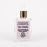 Back of MIni Behrhaus Rose Magnesium Oil bottle showing ingredients label on white. background